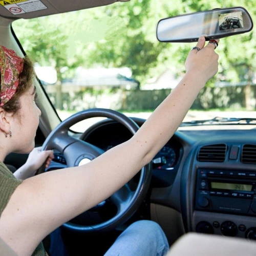 girl adjusts Rearview Mirror in car